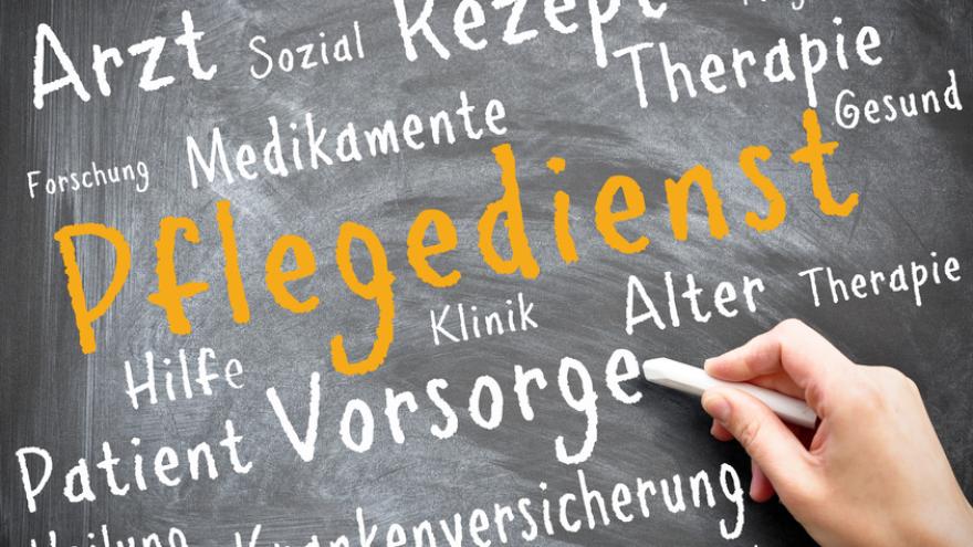 Auf einer Tafel hat jemand das Wort Pflegedienst mit einer Kreide geschrieben